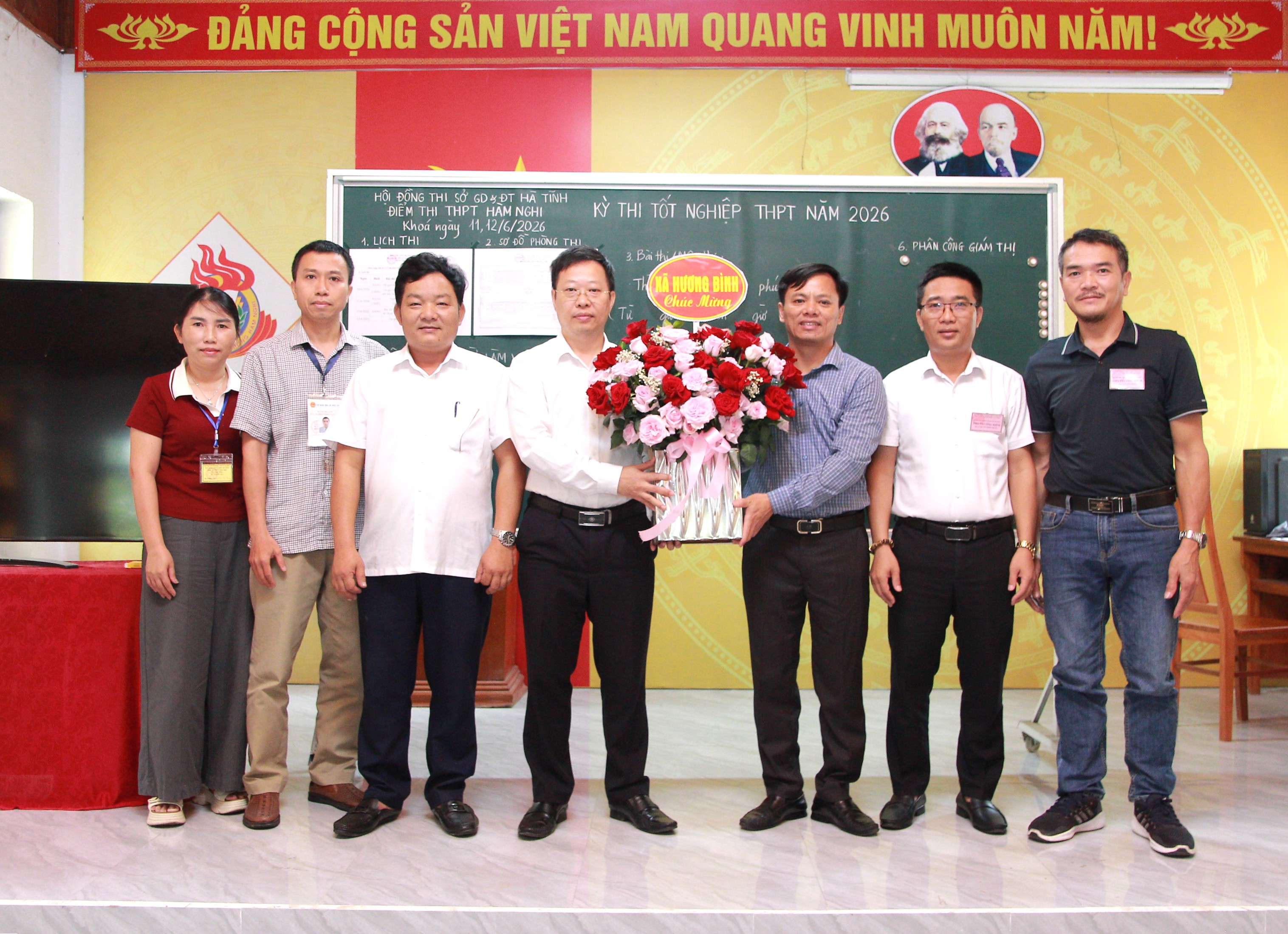 Bí thư Đảng ủy xã Hương Bình tặng hoa chúc mừng Hội đồng thi tại trường THPT Hàm Nghi